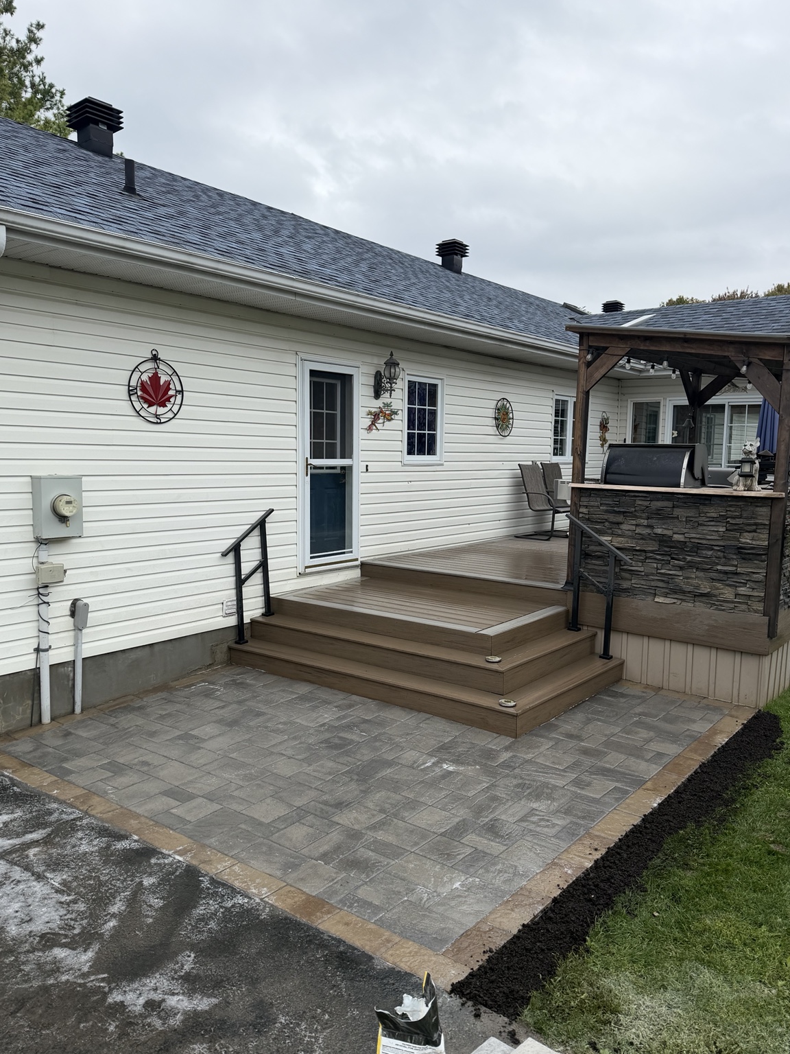 RW Contracting interlock patio meeting wooden deck steps at an Ottawa area home
